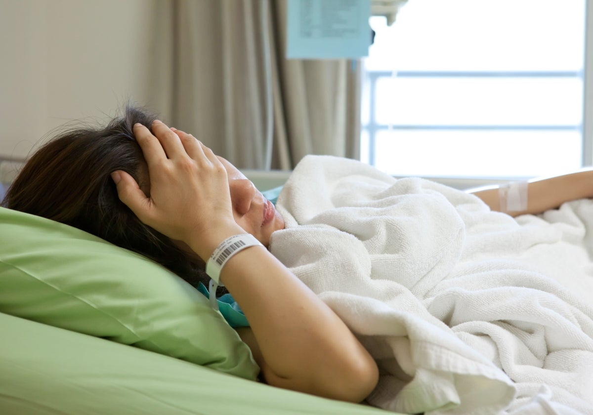 Una paciente descansa en la cama del hospital en el que está ingresada.