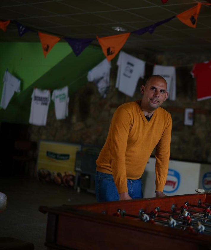 Imagen secundaria 2 - De arriba abajo, Fernando delante de su casa de piedra, que construyeron sus tatarabuelos; bebiendo agua en la fuente de la plaza de Benamira; y en el local social del pueblo donde hay un futbolín.