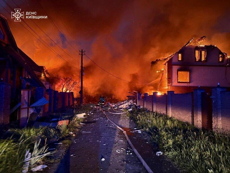 Una calle a las afueras de Kiev flanqueada por edificios destruidos y en llamas tras el ataque nocturno.