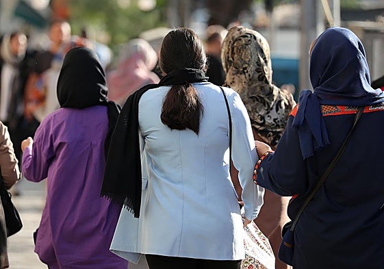 Varias mujeres con pañuelo y otra sin él en las calles de Teherán.