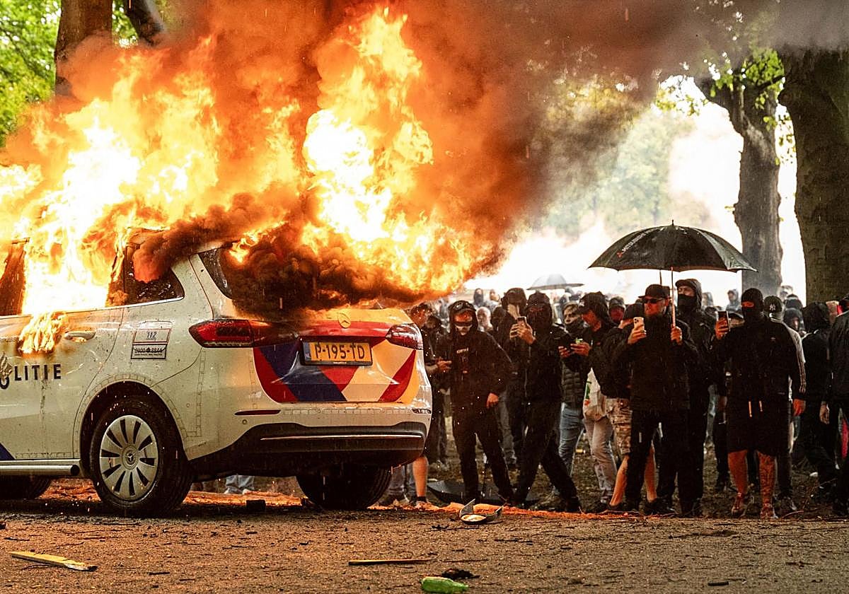 Un coche de la Policía fue incendiado por los manifestantes este sábado en La Haya, que es sede del Gobierno de Países Bajos.