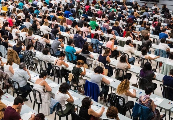 Un grupo de personas examinándose de unas oposiciones a la administración pública.