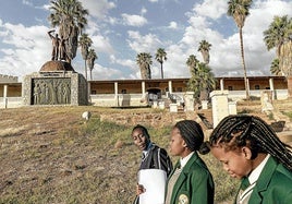 Colegialas namibias caminan junto a un monumento a las víctimas del genocidio perpetrado por las fuerzas alemanas contra los pueblos herero y nama en 1904.