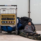 Un sinhogar duerme en el suelo de la terminar aérea madrileña de Barajas.