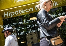 Una persona frente a un escaparate bancario.