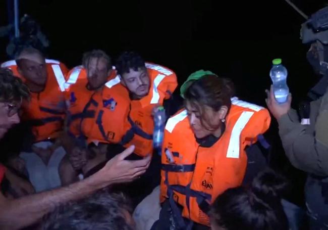 Un soldado israelí da agua a los miembros del barco de ayuda humanitaria.