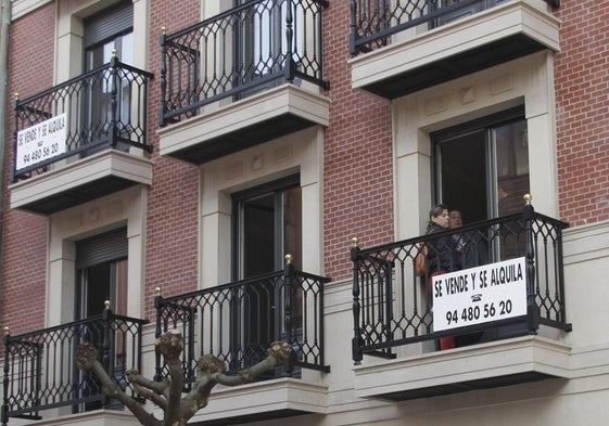 Un cartel de un edificio donde se venden y alquilan viviendas.