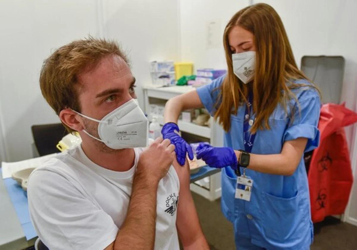 Un joven es vacunado de la gripe en un centro de salud