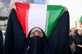 Una mujer ondea una bandera iraní en una protesta contra EE UU en Teherán.