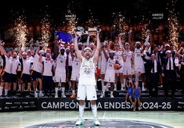 Sergio Llull levanta el trofeo de la Liga ACB en presencia de la plantilla y el cuerpo técnico del Real Madrid.