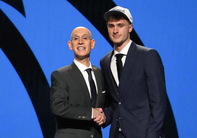 Adam Silver, comisionado de la NBA, estrecha la mano de Cooper Flagg.