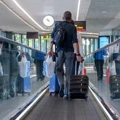 Viajero con equipaje de mano en el aeropuerto.