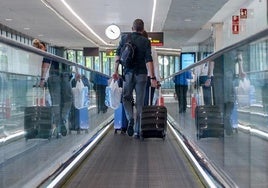 Viajero con equipaje de mano en el aeropuerto.