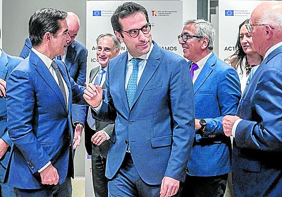 El ministro de Economía, Carlos Cuerpo, entre el presidente de BBVA, Carlos Torres, y el de Sabadell, Josep Oliu