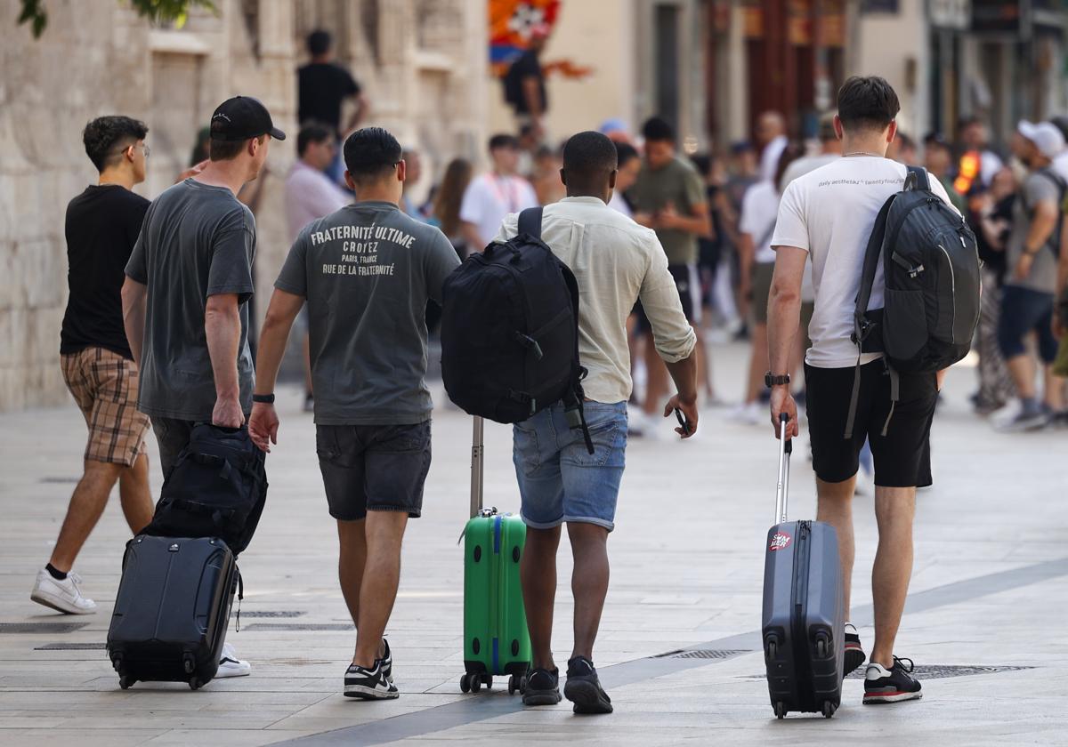 Varios turistas con sus maletas por el centro de Valencia.