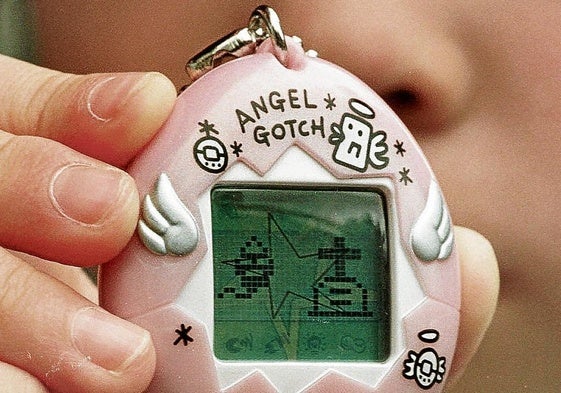 Una niña muestra su tamagotchi en 1997.