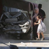 Una madre y su hija corren a refugiarse durante un ataque israelí en el campamento de Al-Bureij, en el centro de Gaza.