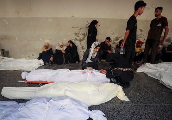 Palestinos lloran junto a varios cadáveres tras un ataque israelí contra una escuela de la UNRWA en Gaza donde se refugiaban desplazados.