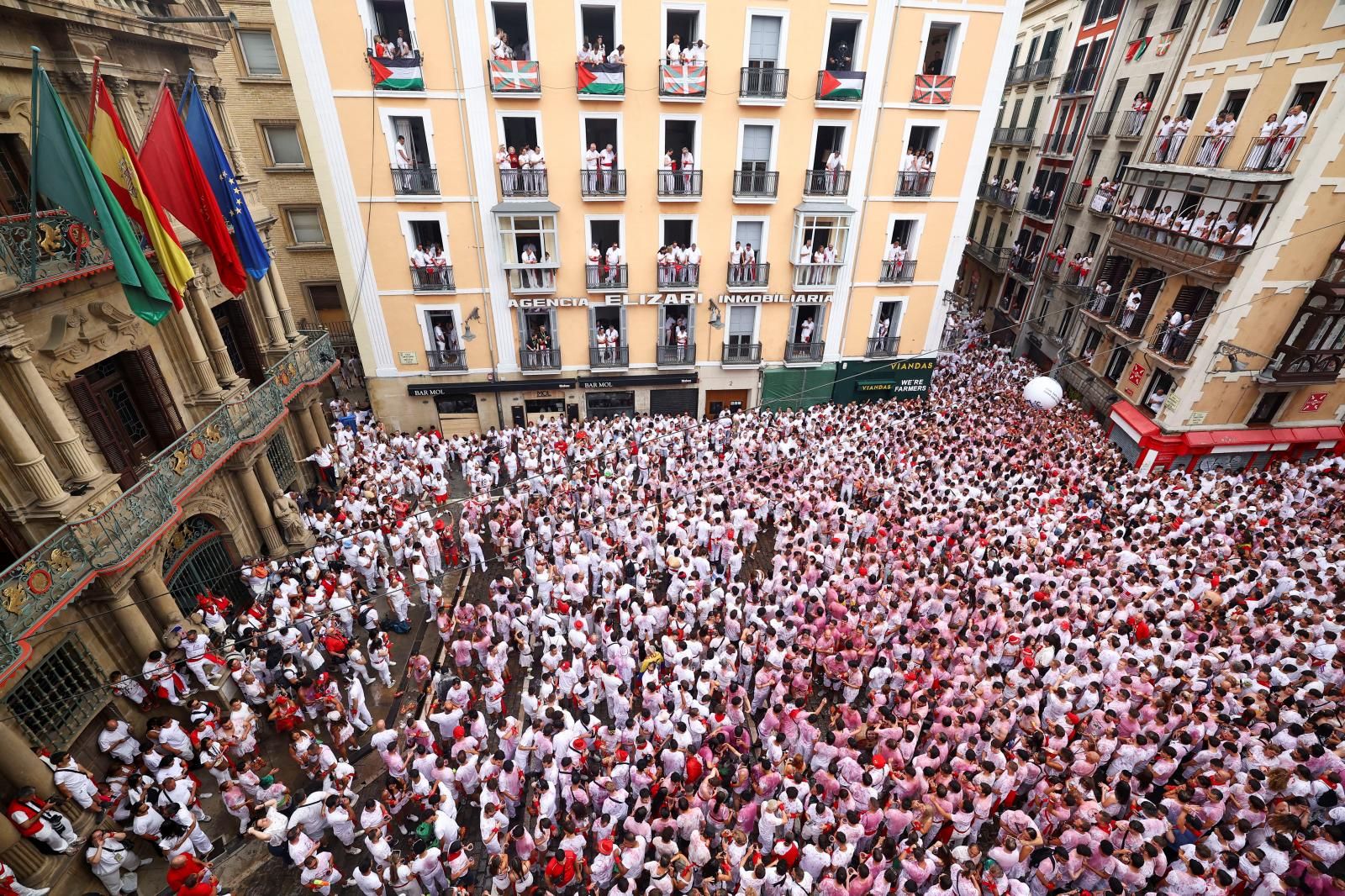 El Casco Viejo de Pamplona se ha llenado de vida: peñas en movimiento, pasacalles y miles de personas luciendo el clásico atuendo blanco y rojo, ese que con el paso de las horas va oscurenciéndose.