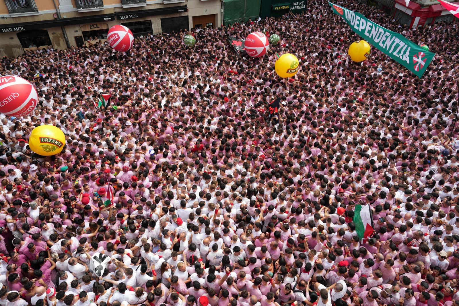 El Casco Viejo de Pamplona se ha llenado de vida: peñas en movimiento, pasacalles y miles de personas luciendo el clásico atuendo blanco y rojo, ese que con el paso de las horas va oscurenciéndose.