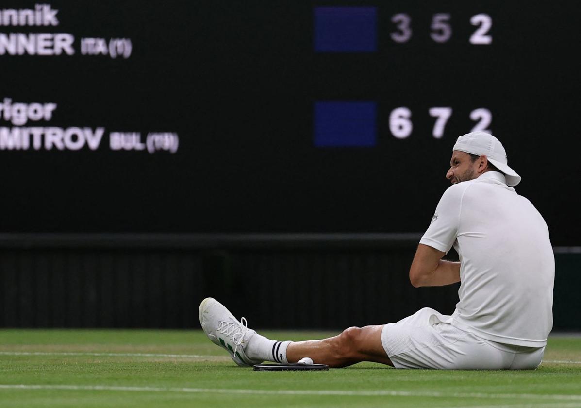 Grigor Dimitrov, roto por el dolor, tiene que sentarse sobre la pista de Wimbledon al no poder continuar este lunes su partido.