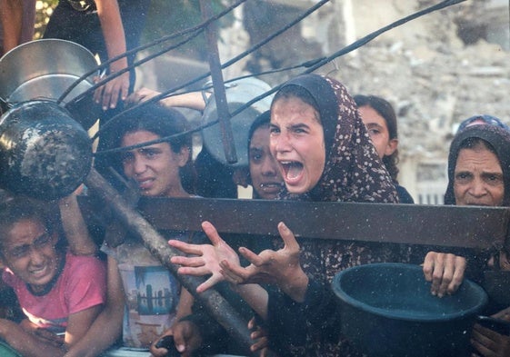 Varios niños se amontonan en un punto de distribución de alimentos en Ciudad de Gaza.