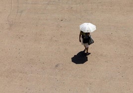 Una mujer se protege del sol con un paraguas en Valencia.