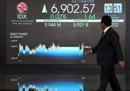 Un operador camina ante las patallas de cotización de la Bolsa de Indonesia.