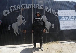 Un agente vigila la entrada al rancho Izaguirre durante un registro judicial en la localidad mexicana de Teuchitlán, Jalisco.