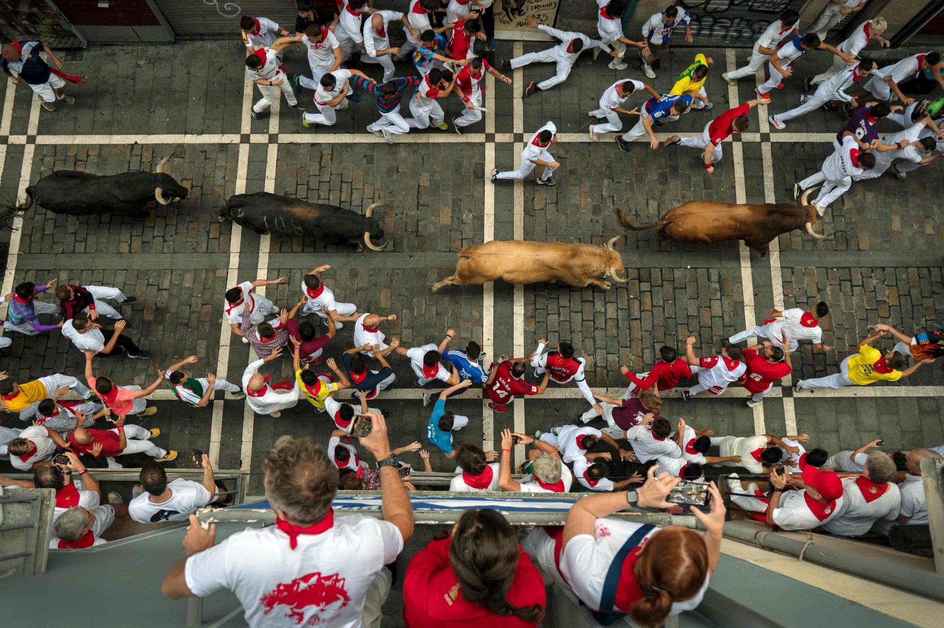 Imagen cenital desde uno de los balcones en la que se ve a los mozos correr junto a los toros de la ganadería Jandilla. 