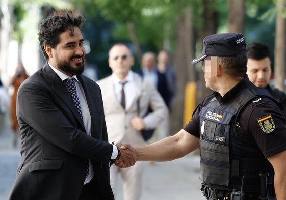 El eurodiputado Alvise Pérez saluda este viernes a un policía en el Tribunal Supremo antes de declarar por presunta financiación irregular de su partido.