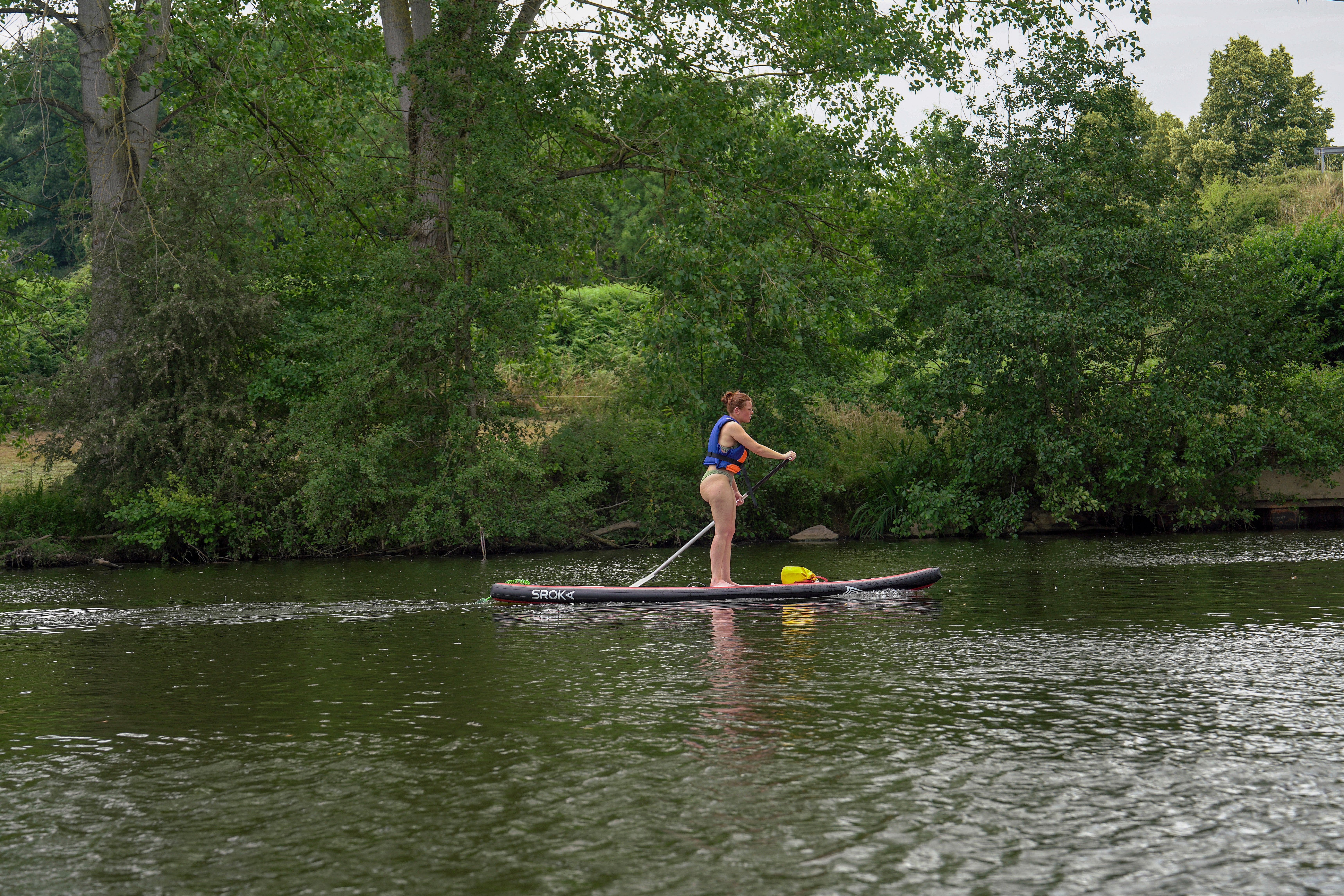 Una joven practica paddle surf en las aguas del Mayenne. Las actividades acuáticas, así como la navegación en barcas eléctricas, son un atractivo para el visitante en este río navegable. Laval, Francia.