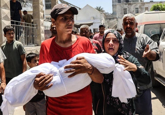 Una familia traslada el cadáver de su hijo, asesinado en un bombardeo en Gaza City.
