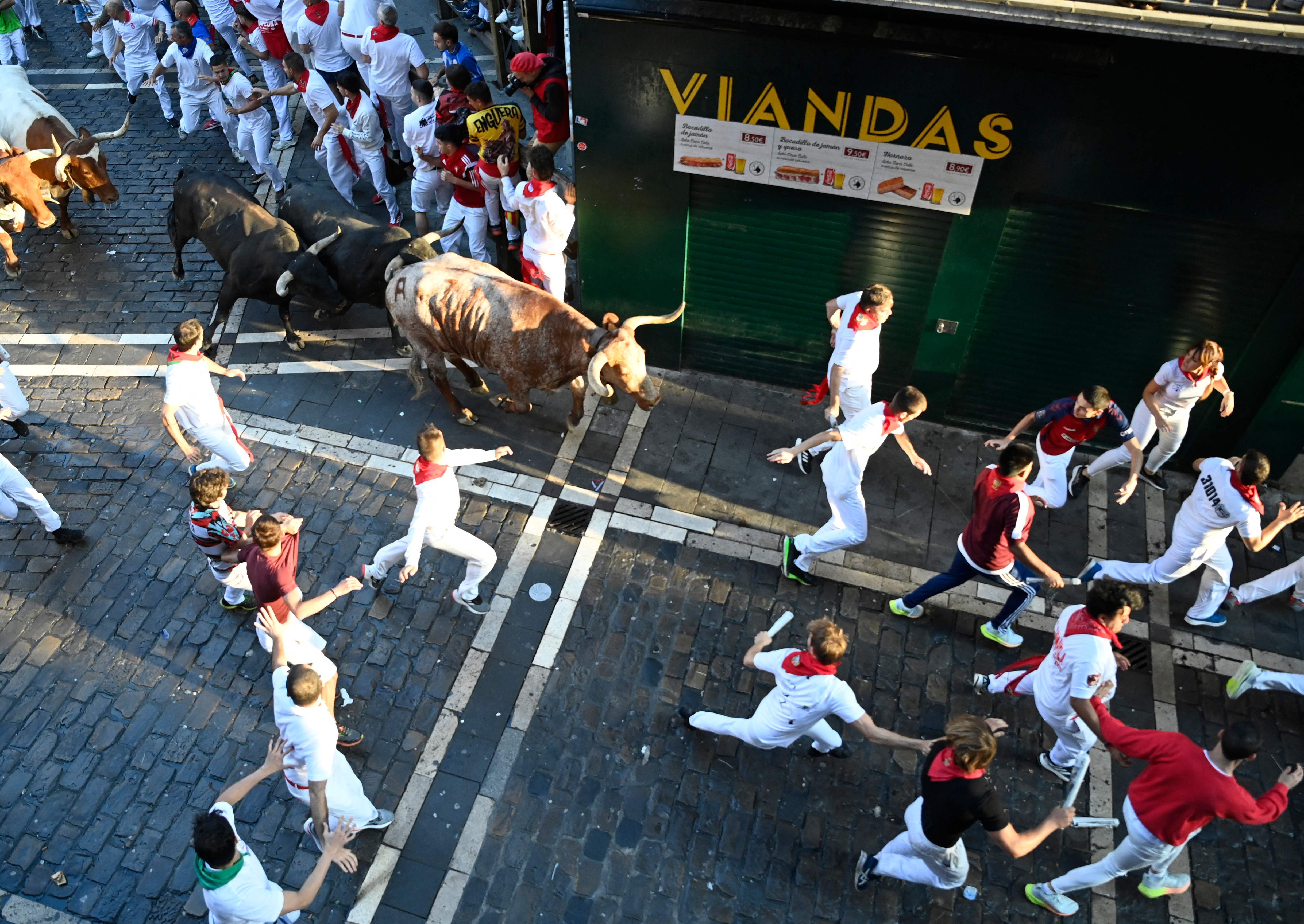 Los mozos huyen de los Miura con los primeros rayo de sol de la mañana en Pamplona.