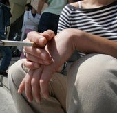 Una joven fumando un cigarrillo en las escaleras de la Facultad de Medicina