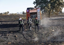 Los bomberos tratan de apagar este viernes los rescoldos del fuego, que se originó en Méntrida.