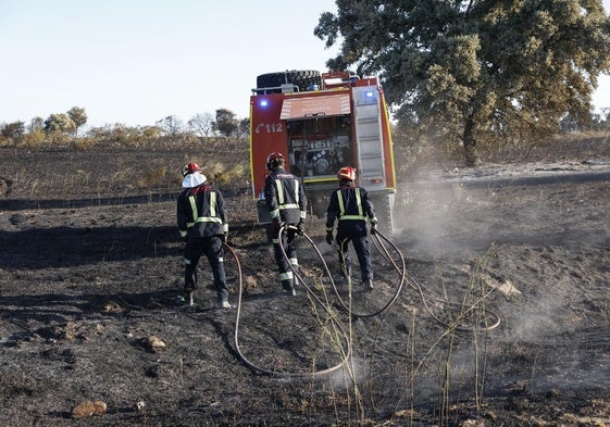 Los bomberos tratan de apagar este viernes los rescoldos del fuego, que se originó en Méntrida.