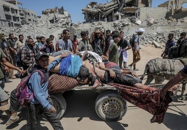 Los cadáveres de palestinos fallecidos este domingo en el centro de reparto de ayuda en el norte de Gaza son trasladados en una carreta.