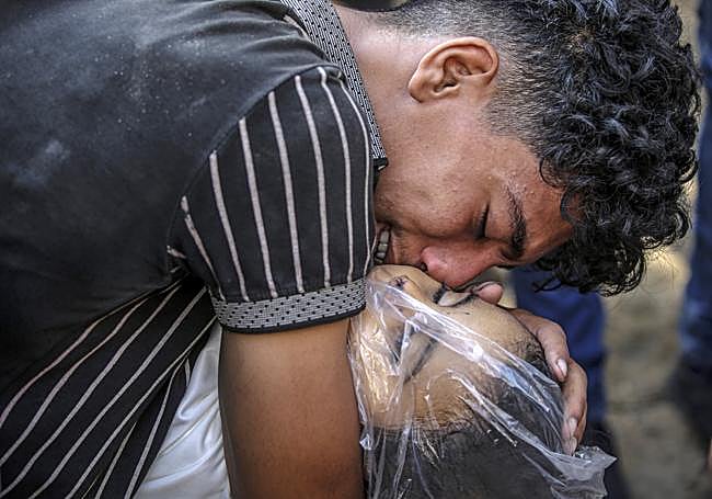 Un joven llora a su hermano muerto.