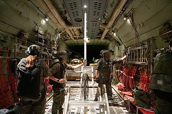 Los militares llenan un avión con el primer envío aéreo de alimentos a Gaza.