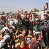 Un grupo de gazatíes celebra el reparto de comida en el campamento de Al-Mawasi, en Rafah.
