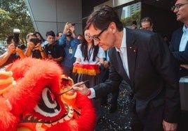 El presidente de la Generalitat, Salvador Illa, pinta sobre un dragón, durante su visita este viernes a Shangai.