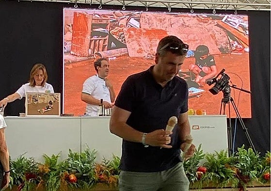 Angelines González y Fernando Sáenz, durante la presentación del helado que se dispone a degustar uno de los asistentes al festival gastronómico Mama; al fondo, imágenes del paisaje arrasado por la dana que inspiran su creacion.