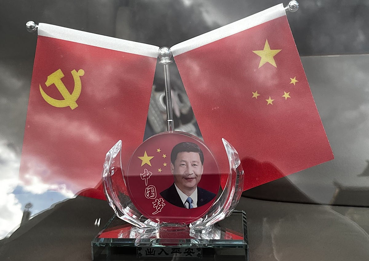 Imagen secundaria 1 - Un crío con su triciclo ante un cartel político ante las calles en Lhasa. La imagen de Xi Jinping en los autobuses, y una presentación en la feria FamTrip de Pekin.
