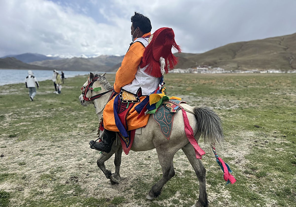 Imagen principal - Un campesino en una caballería en la ribera del sagrado lago Yamdrock. Motocarros eléctricos en las calles de Shigatse. Clientes tibetanos en restaurante popular de Lhasa, en el barrio de Barkhor, donde se consume te con 'ghee', matequilla de yak. 