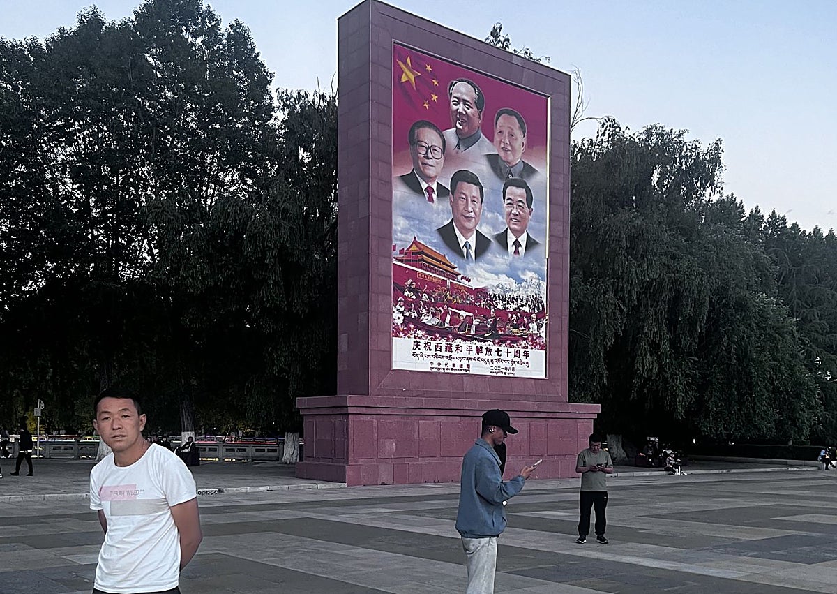 Imagen secundaria 1 - El palacio Potala al atardecer. Un enorme cartel político con todos los mandatarios chinos de Mao a Xi Jinping en la explanada bajo el palacio, y tres monjes contemplando la Lhasa moderna desde un mirado del la fachada posterior del Potala.