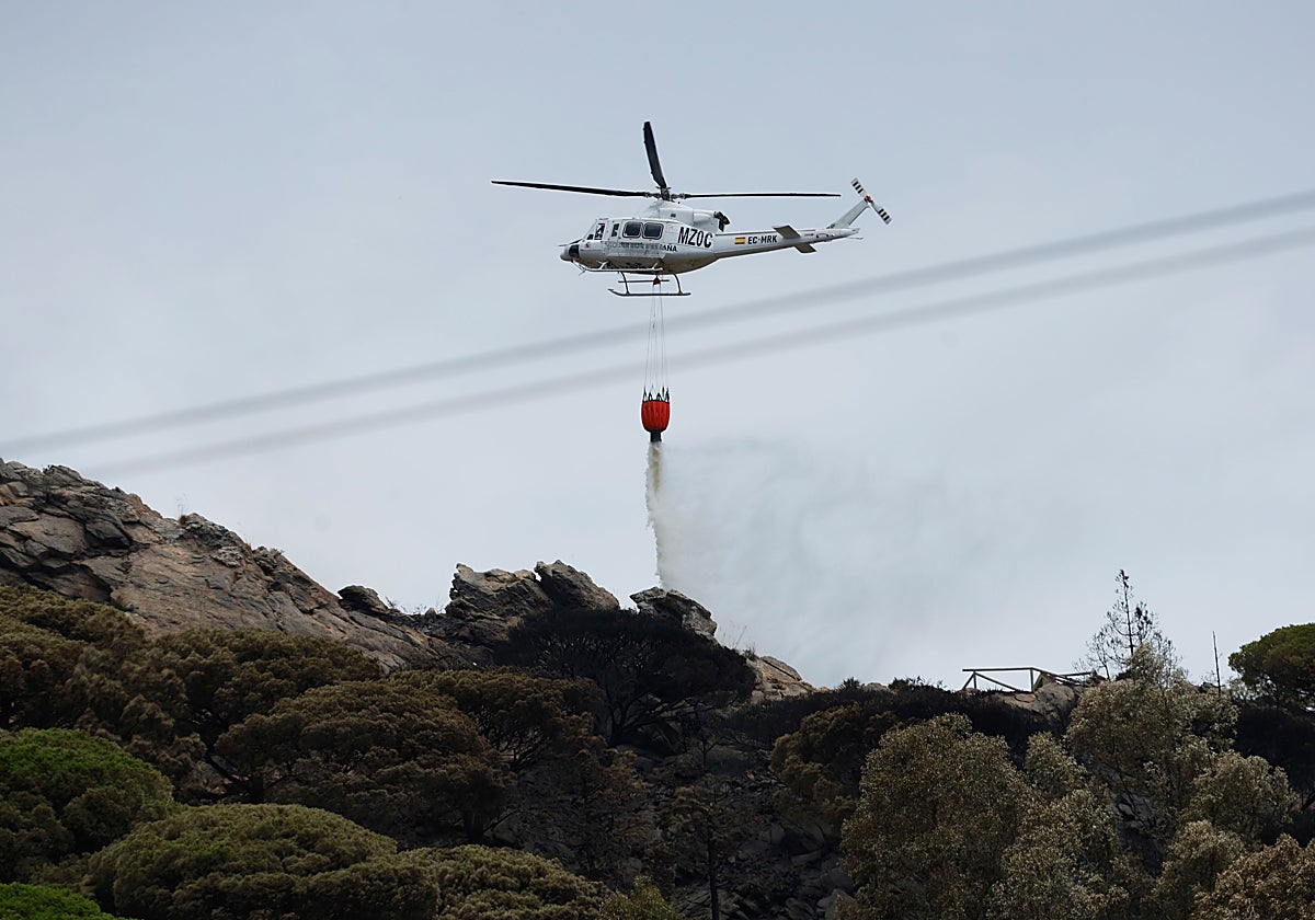 Un helicóptero trata de cortar el avance del fuego en Tarifa (Cádiz).