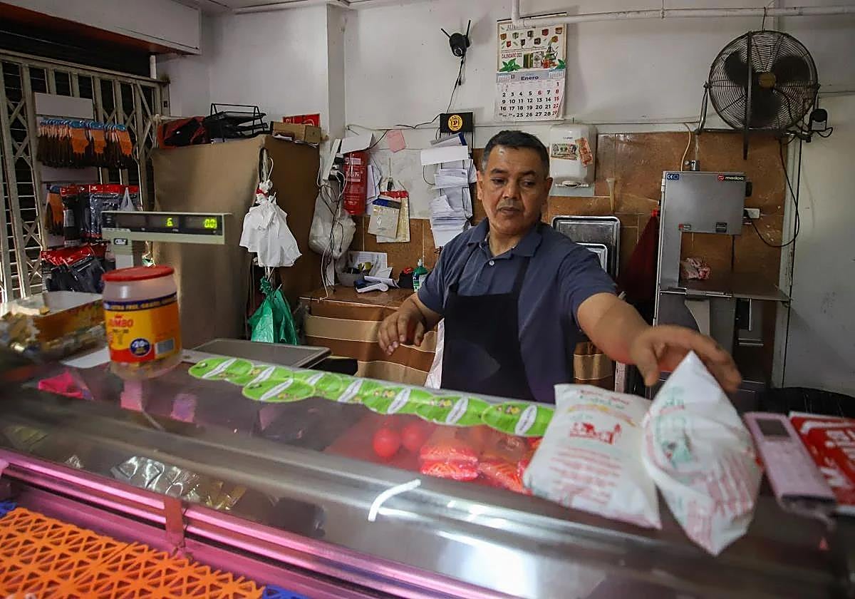 Mohamed, en su local de frutas y verduras, atiende a varios clientes este jueves.