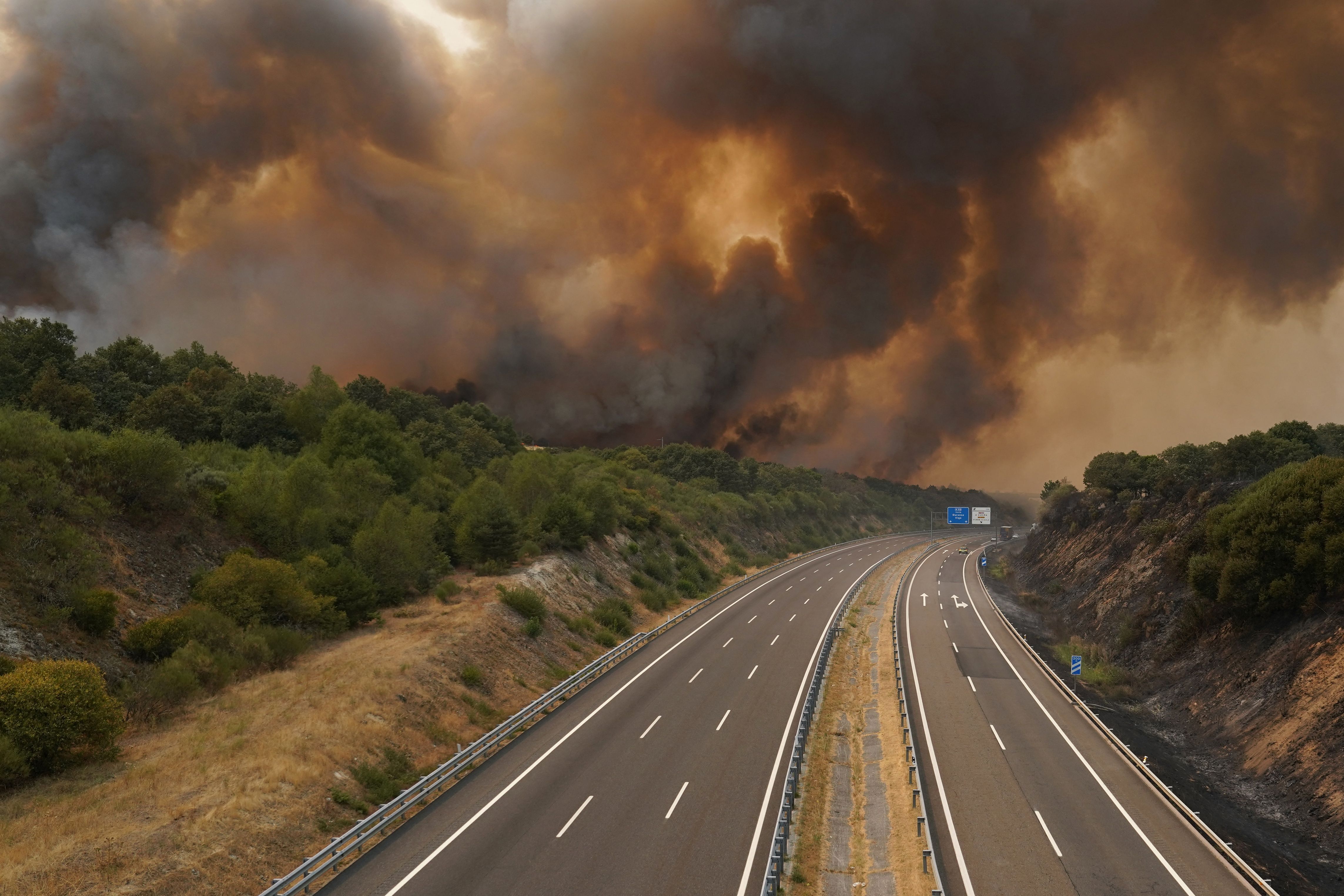 Un incendio forestal arde cerca de una carretera en La Gudiña, Orense.