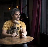 Ernesto Sevilla en un bar de Madrid junto a su galgo italiano, Elvis, que le acompaña desde 2019.